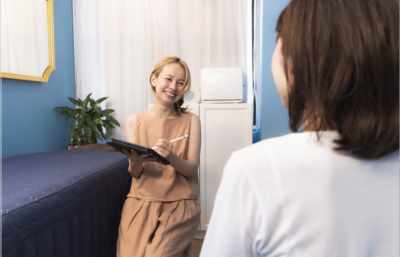 施術のまえに、タブレットを手にお話をうかがっているところ。